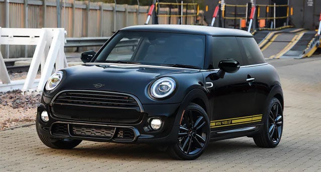 The MINI Cooper 1499 GT Special Edition driving by a construction site.