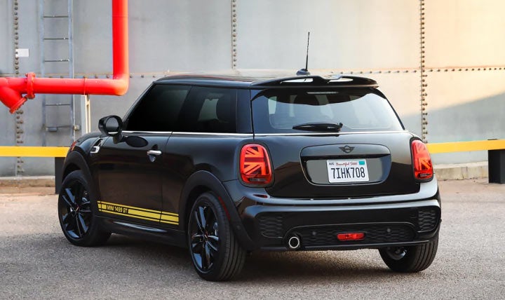 A rear view The MINI Cooper 1499 GT Special Edition parked in front of a garage.