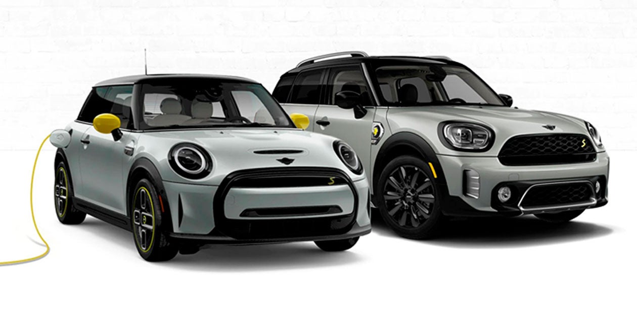 Two MINI Electric vehicles with one on left being charged.