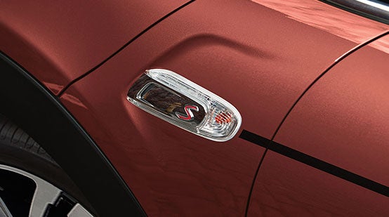 A close-up of the MINI COOPER HARDTOP CORAL RED EDITION's Coral Red Metallic exterior paint and Black Pinstripe.