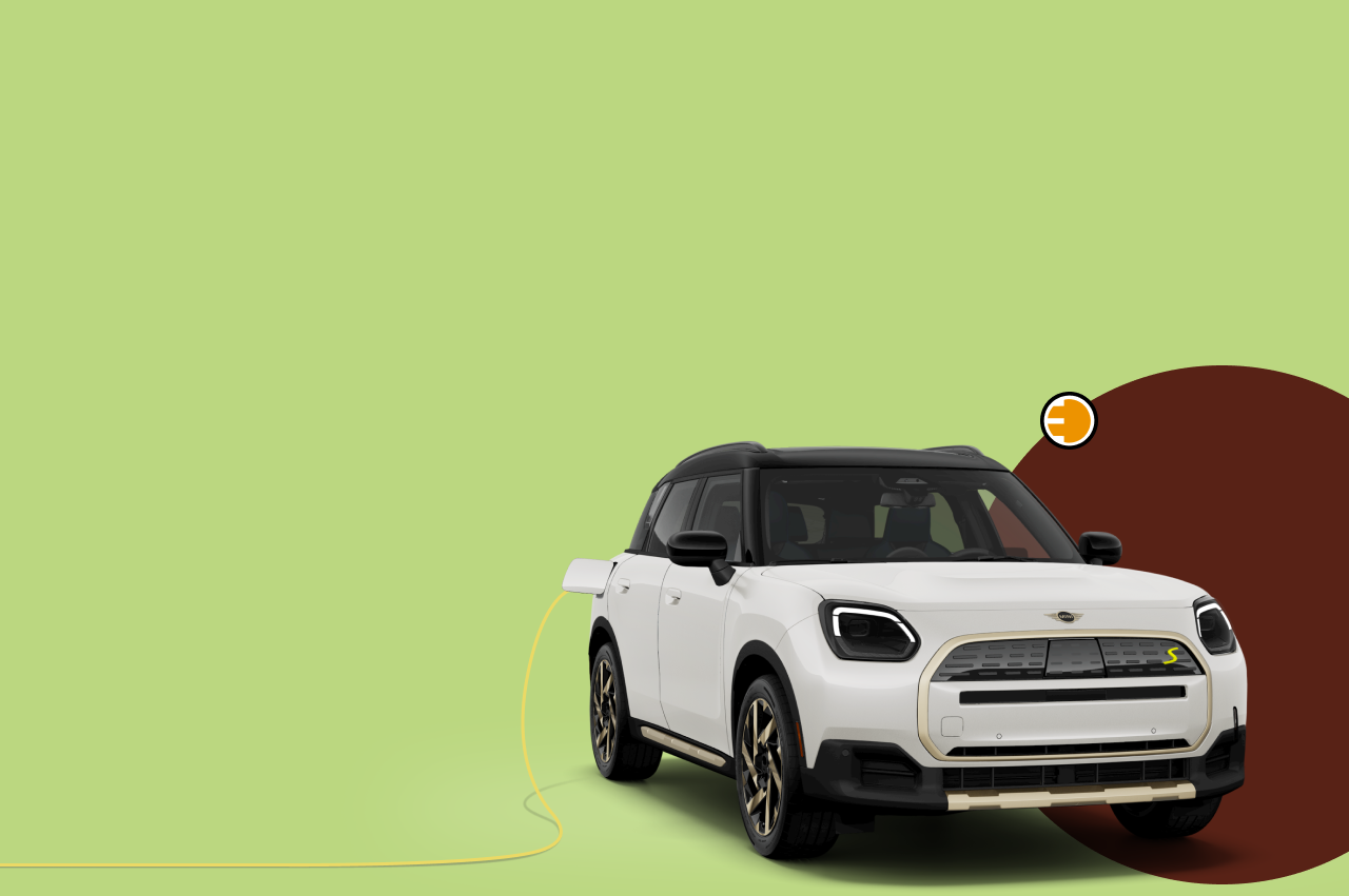 Angled view of a MINI Countryman SE ALL4 with a brown circle behind it against a green background.