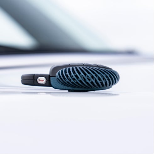 Closeup view of the signature MINI Cooper S Convertible Seaside Edition key sitting on the hood of a MINI Cooper S Convertible Seaside Special Edition in Nanuq White.